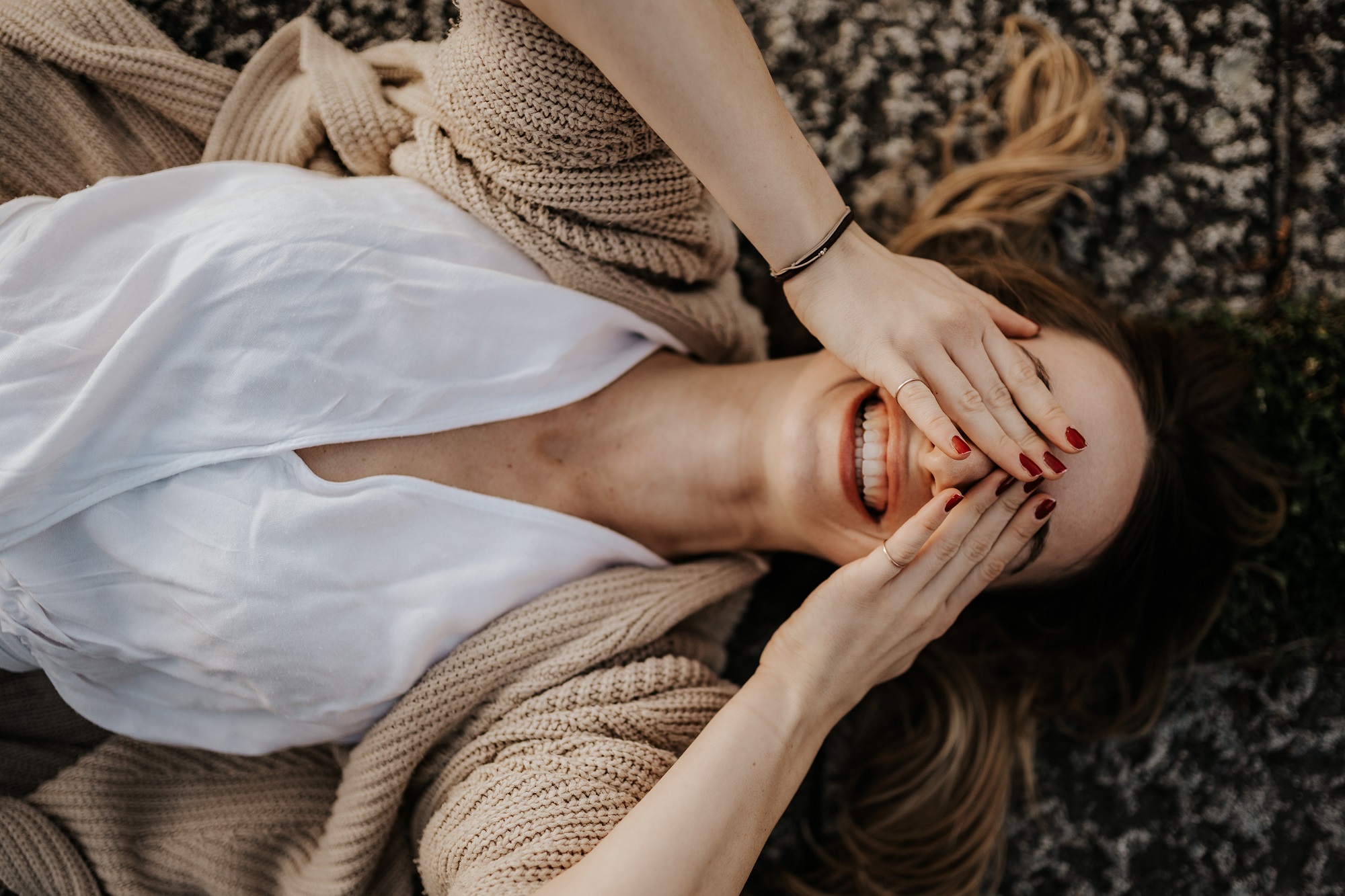 Portrait Foto von einer Frau, die am Boden liegt und sich die Augen zuhält