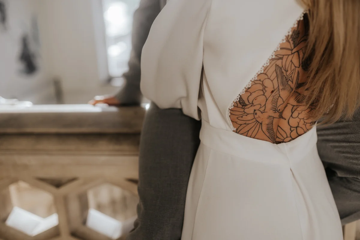 Detail-Foto eines tätowierten Rückens einer Braut, fotografiert bei einem unkonventionellen Hochzeit-Shooting im Medienkulturhaus Wels, von Hochzeitsfotograf Kosia