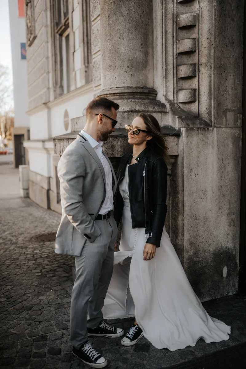 Cooles Brautpaar mit Sonnenbrillen und Lederjacke vor dem Medienkulturhaus, fotografiert bei einem Hochzeit-Shooting in Wels, von Hochzeitsfotograf Kosia