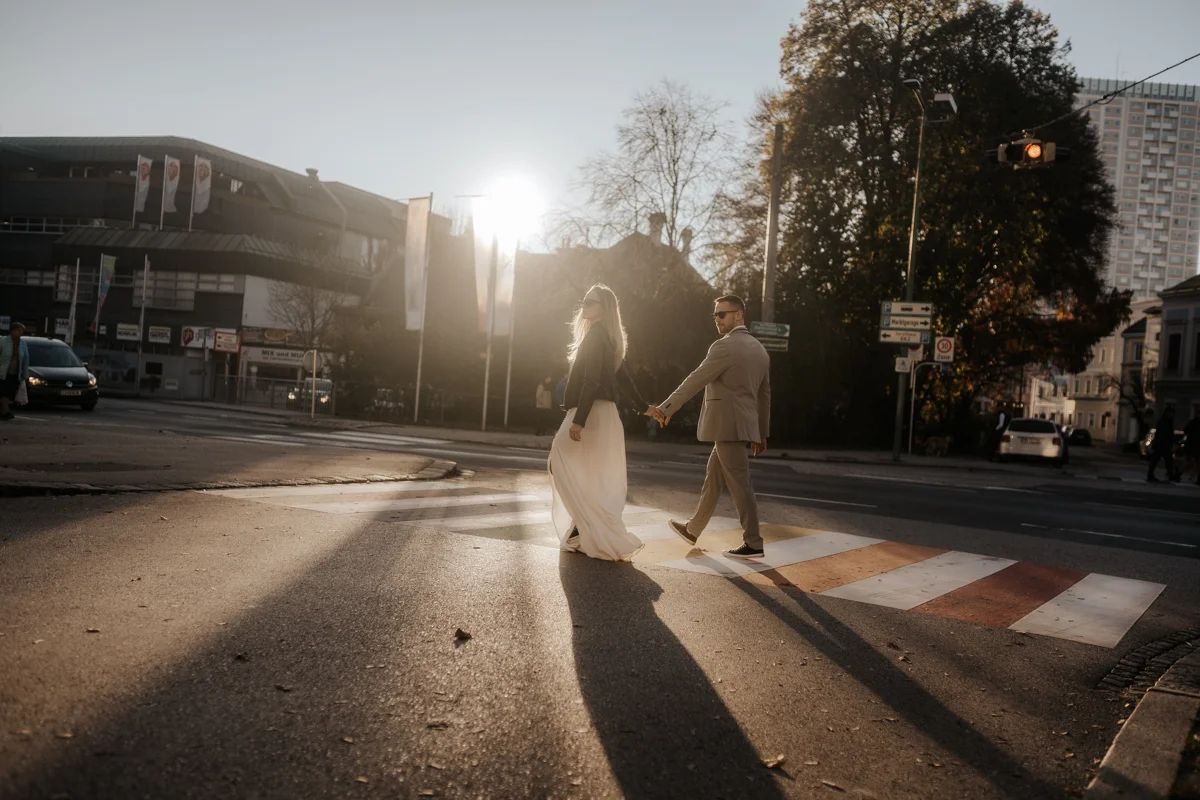 Brautpaar das bei Sonnenuntergang über einen LGBTQ-Zebrastreifen läuft, fotografiert bei einem Hochzeit-Shooting in Wels
