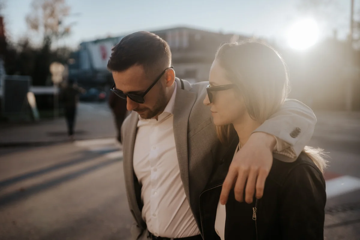Brautpaar mit Sonnenbrillen läuft legere durch die Welser Innenstadt, fotografiert bei einem Hochzeit-Shooting