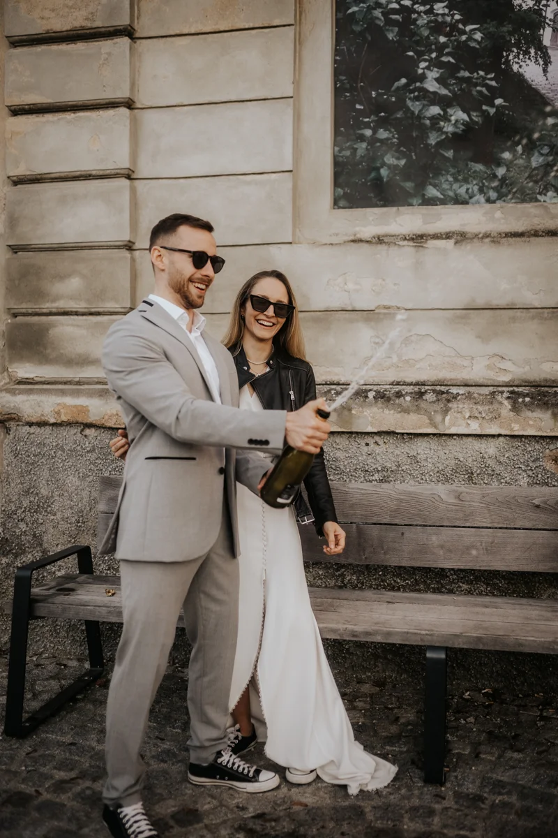 Brautpaar feiert ihre Liebe und spritzt mit Sekt herum, fotografiert bei einem Hochzeit-Shooting in Wels