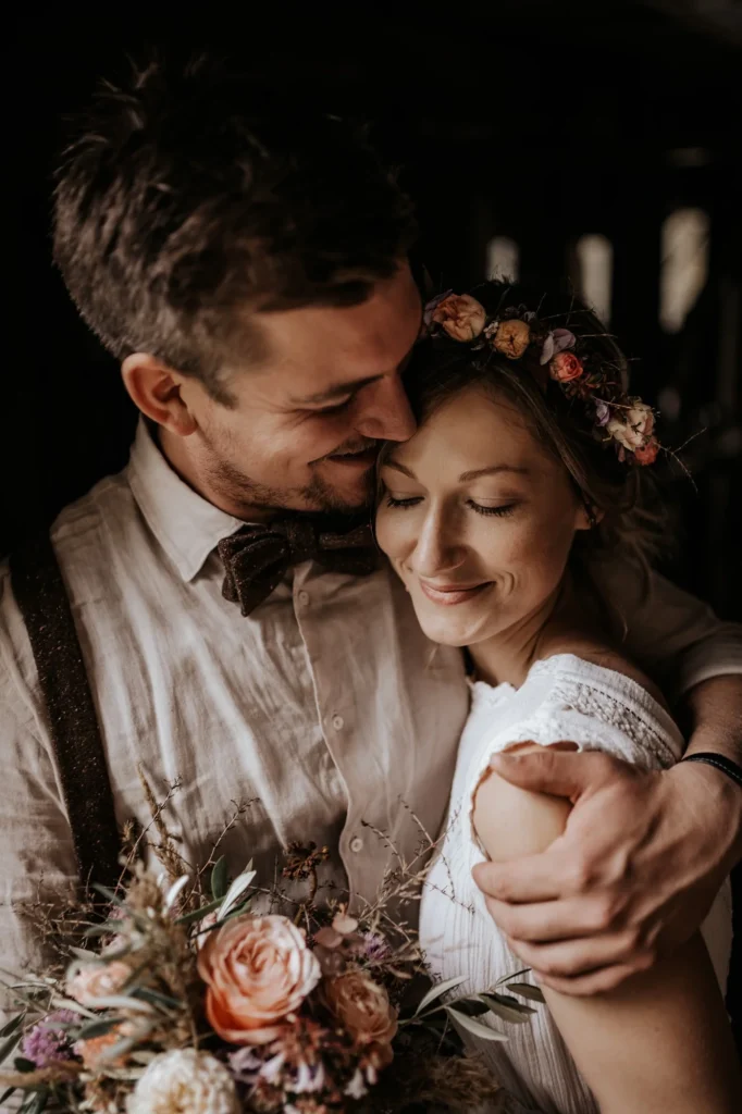 Braut und Bräutigam im Boho-Stil umarmen sich innig, fotografiert von Hochzeitsfotograf Nicole Salfinger aus Oberösterreich