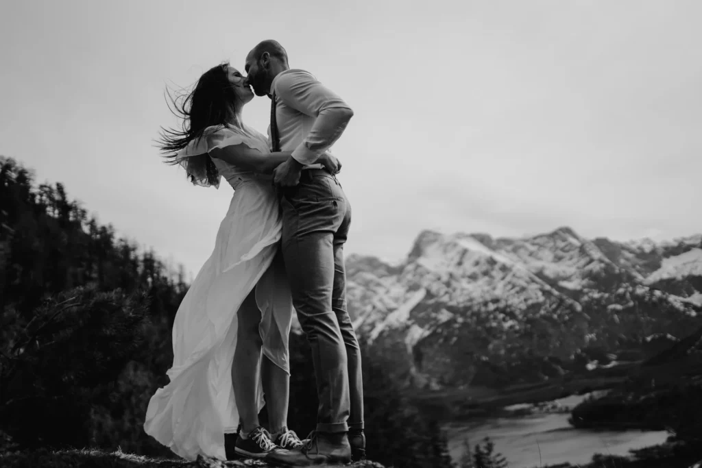 Brautpaar am Berg bei einer Elopement-Hochzeit in Österreich, fotografiert von Elopement Fotograf Kosia Photography. Im Hintegrund ist eine Bergkulisse zu erkennen.